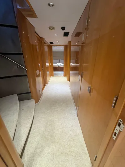  Yacht Photos Pics Luxurious hallway inside 2000 Baglietto 116 yacht, featuring wooden paneling and carpeted flooring.