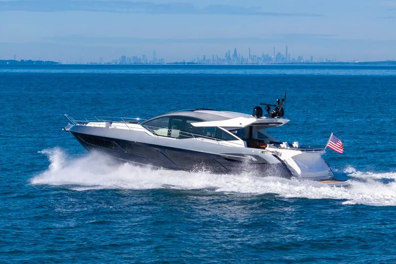 Kb Jr Yacht Photos Pics 2020 Sunseeker Predator 74 yacht cruising on open water with city skyline in background.