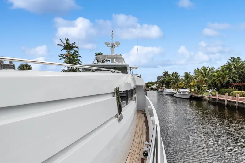 Yacht Photos Pics Oceanfast 1989 Motor Yacht cruising along a scenic, palm-lined waterway.