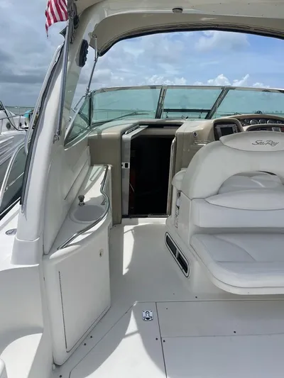 Adagio Yacht Photos Pics 1999 Sea Ray 380 Sundancer boat interior with white seating and helm, under cloudy sky.