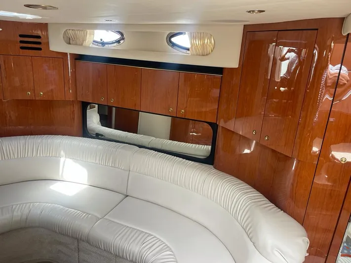 Adagio Yacht Photos Pics Luxurious interior of 1999 Sea Ray 380 Sundancer with white leather seating and wooden cabinets.