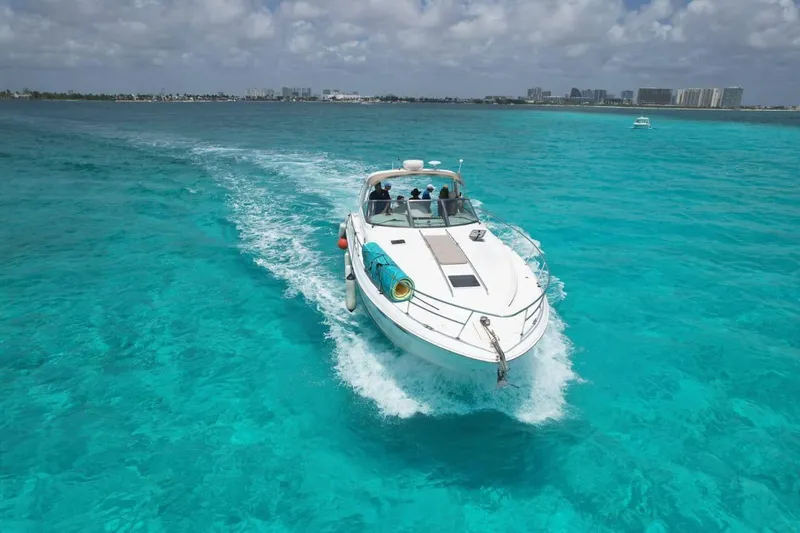 Adagio Yacht Photos Pics 1999 Sea Ray 380 Sundancer cruising on clear turquoise waters under a partly cloudy sky.