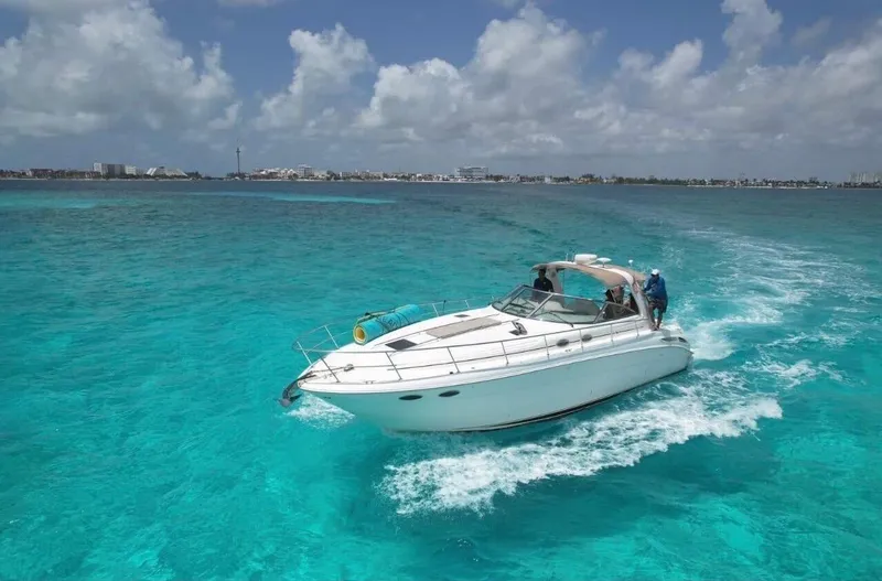 Adagio Yacht Photos Pics Sea Ray 380 Sundancer 1999 cruising on clear turquoise waters under a partly cloudy sky.
