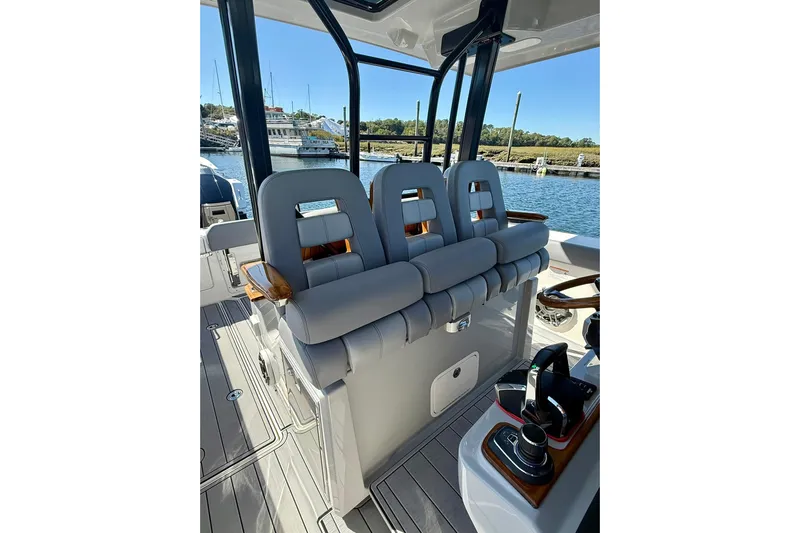 Ghost Rider Yacht Photos Pics 2024 Boston Whaler 360 Outrage boat interior with cushioned seating and control panel.