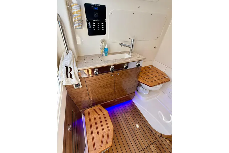 Ghost Rider Yacht Photos Pics Luxurious interior of 2024 Boston Whaler 360 Outrage boat with wooden cabinetry and modern fixtures.