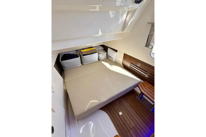 Ghost Rider Yacht Photos Pics 2024 Boston Whaler 360 Outrage cabin interior with cushioned seating and wooden flooring.
