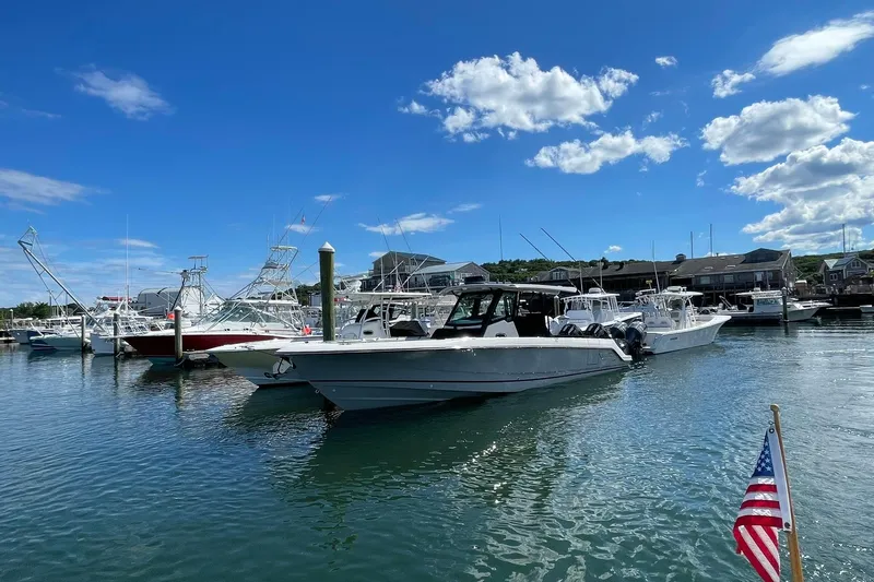 Ghost Rider Yacht Photos Pics 2024 Boston Whaler 360 Outrage docked in a marina under a clear blue sky.