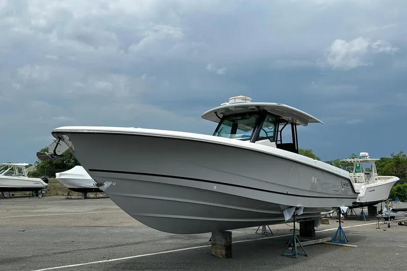 Ghost Rider Yacht Photos Pics 2024 Boston Whaler 360 Outrage boat on stands under cloudy sky.