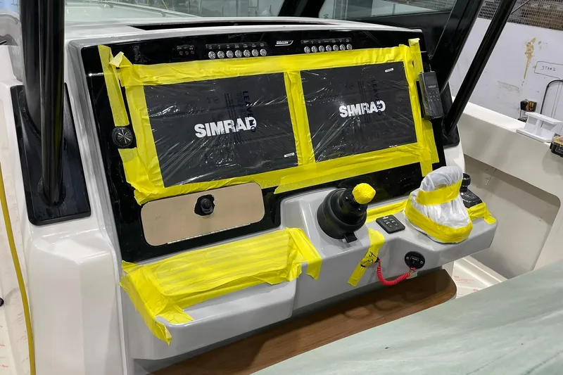 Ghost Rider Yacht Photos Pics 2024 Boston Whaler 360 Outrage dashboard with Simrad displays, partially covered in protective tape.