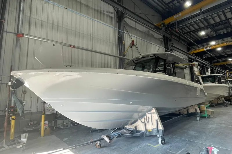 Ghost Rider Yacht Photos Pics 2024 Boston Whaler 360 Outrage boat in a warehouse setting.