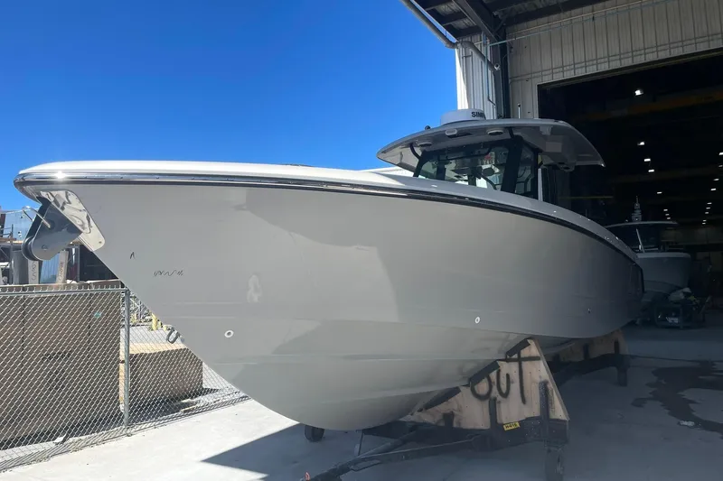 Ghost Rider Yacht Photos Pics 2024 Boston Whaler 360 Outrage boat in a shipyard under clear blue sky.