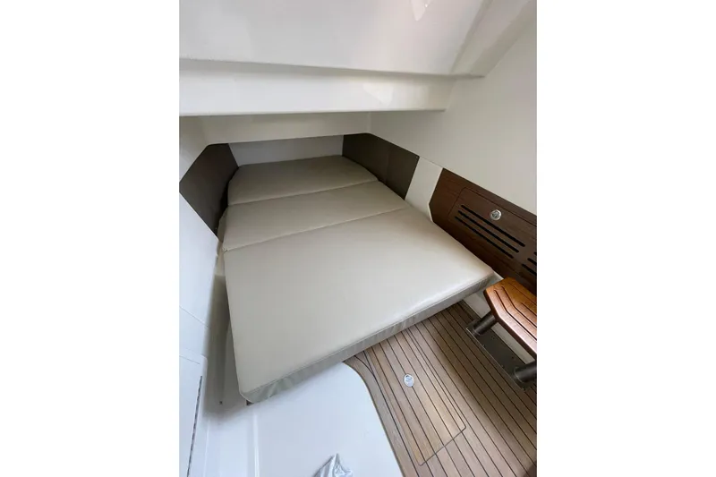Ghost Rider Yacht Photos Pics 2024 Boston Whaler 360 Outrage cabin interior with cushioned bed and wooden flooring.