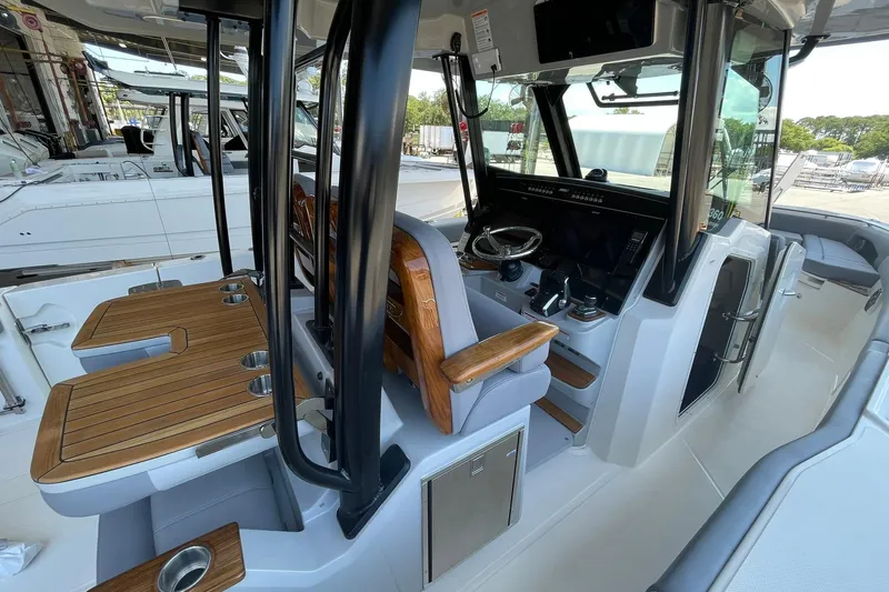 Ghost Rider Yacht Photos Pics 2024 Boston Whaler 360 Outrage interior with helm, seating, and wooden accents.