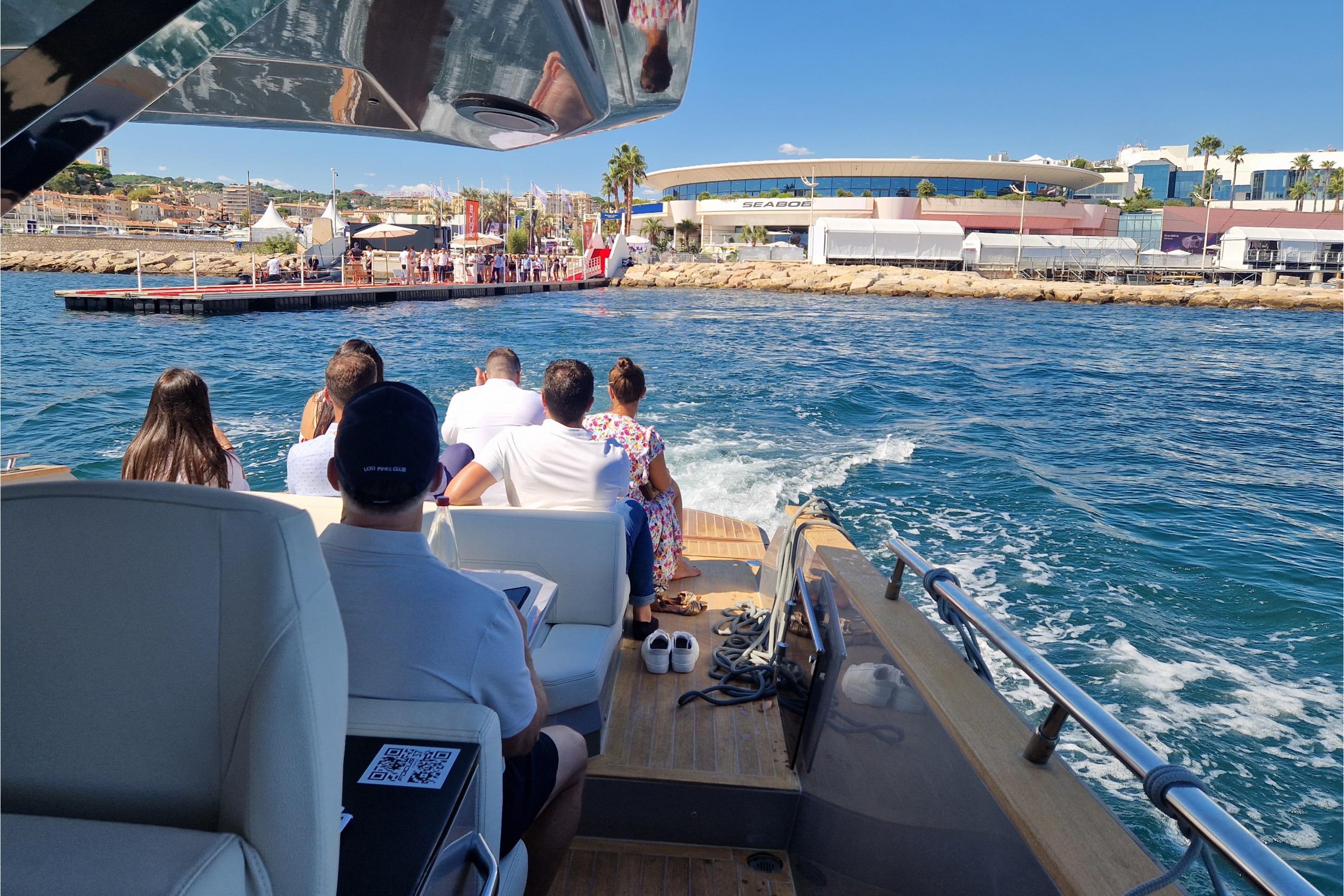 People enjoying a ride on a 2024 Focus Forza 37 yacht near a coastal dock.