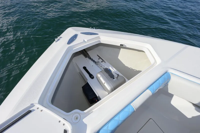  Yacht Photos Pics 2022 SeaVee 340Z boat anchor compartment with blue cushioned seating, on calm water.