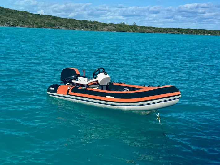Dream On Yacht Photos Pics Leopard 45 inflatable boat, 2022, on turquoise water near green shoreline.