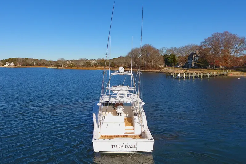 Tuna Daze Yacht Photos Pics 2004 Cabo Express boat named "Tuna Daze" on a calm lake with a scenic shoreline.