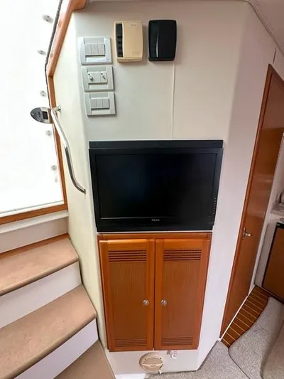 Tuna Daze Yacht Photos Pics 2004 Cabo Express interior with TV, wooden cabinets, and stairs.