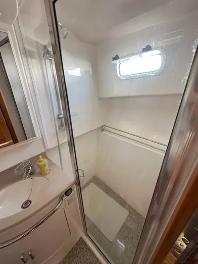 Tuna Daze Yacht Photos Pics 2004 Cabo Express boat bathroom with shower, sink, and window.
