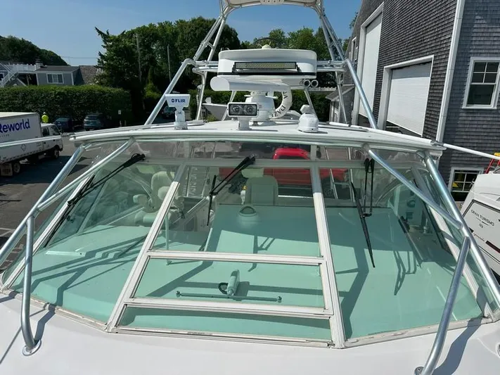 Tuna Daze Yacht Photos Pics 2004 Cabo Express boat with windshield and radar equipment, docked near buildings.