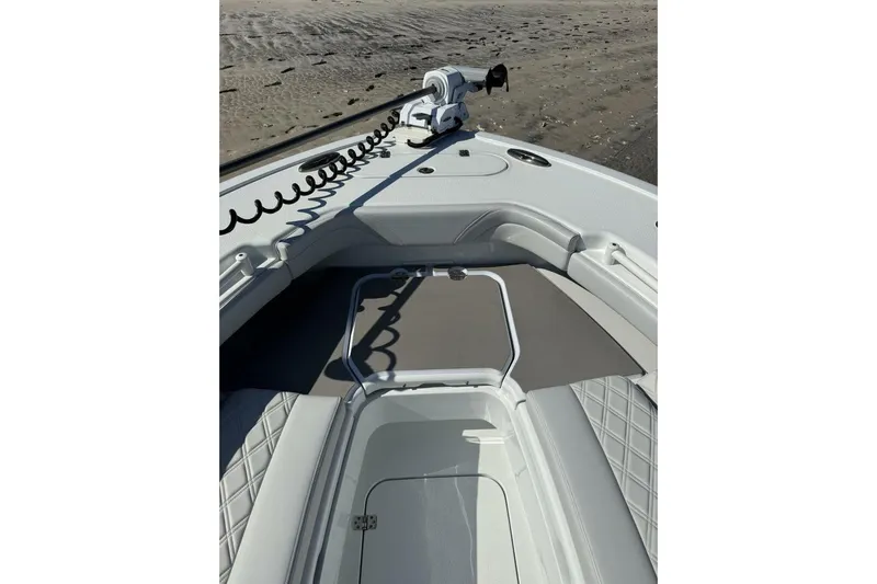  Yacht Photos Pics 2025 Yellowfin 26 Hybrid boat interior with seating and storage, on sandy beach background.