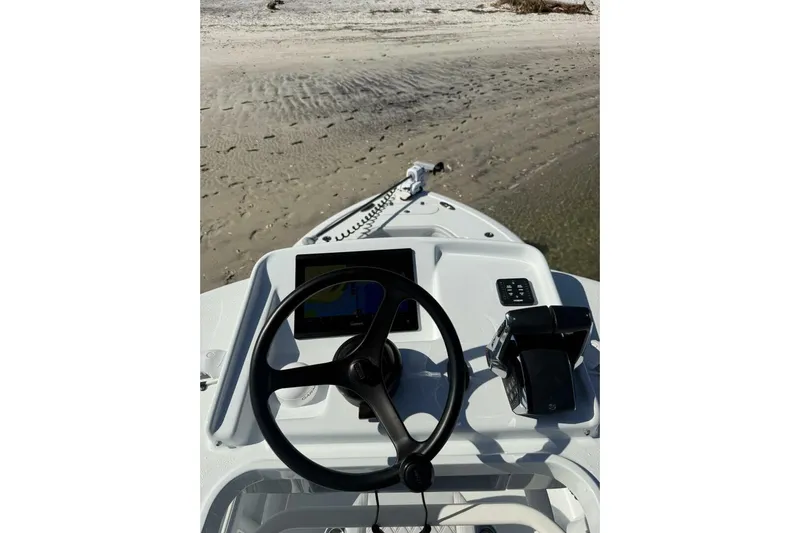  Yacht Photos Pics Steering console of 2025 Yellowfin 26 Hybrid boat on sandy shore.