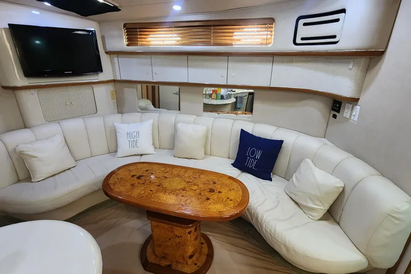 Lemaar Yacht Photos Pics Interior of 1995 Sea Ray 450 Sundancer with white seating and wooden table.