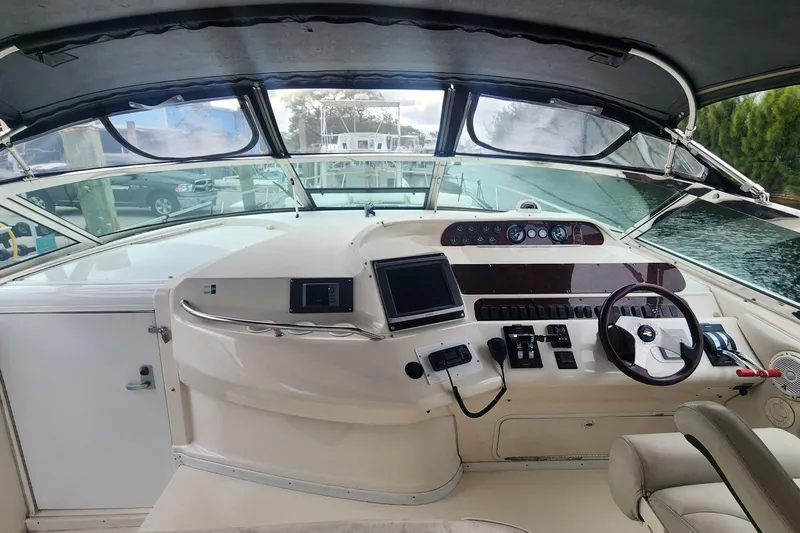 Lemaar Yacht Photos Pics 1995 Sea Ray 450 Sundancer helm with steering wheel, controls, and navigation equipment.
