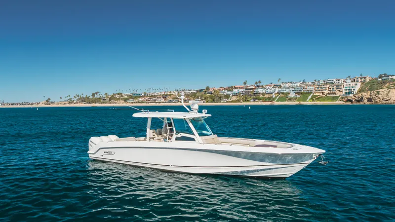 Robin Ann Yacht Photos Pics 2018 Boston Whaler 380 Outrage on clear blue water, coastal background.