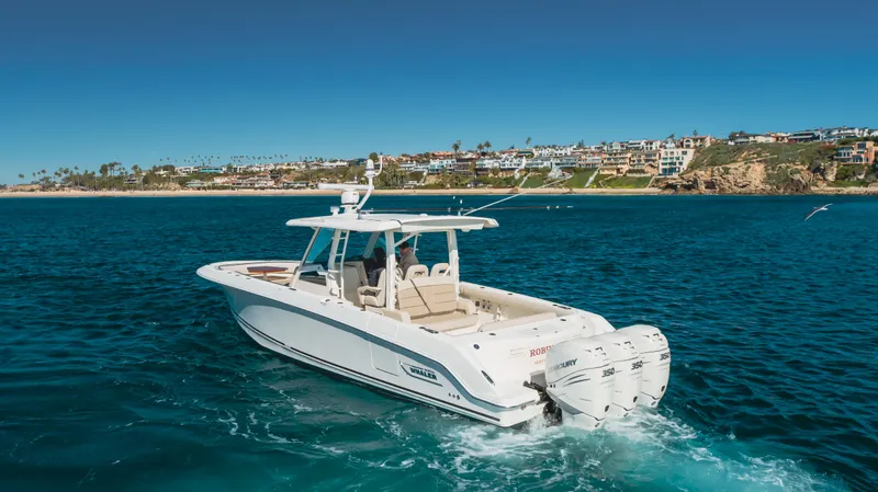 Robin Ann Yacht Photos Pics 2018 Boston Whaler 380 Outrage cruising in clear blue waters near a coastal town.