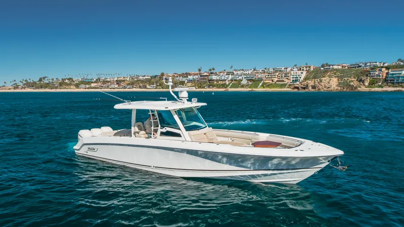 Robin Ann Yacht Photos Pics 2018 Boston Whaler 380 Outrage boat on blue ocean near coastal homes.