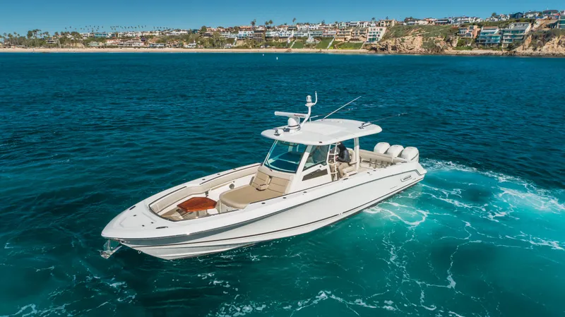 Robin Ann Yacht Photos Pics 2018 Boston Whaler 380 Outrage cruising on blue ocean near scenic coastline.