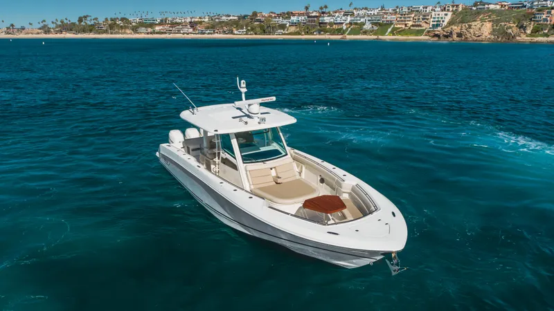 Robin Ann Yacht Photos Pics 2018 Boston Whaler 380 Outrage boat on clear blue water near coastline.