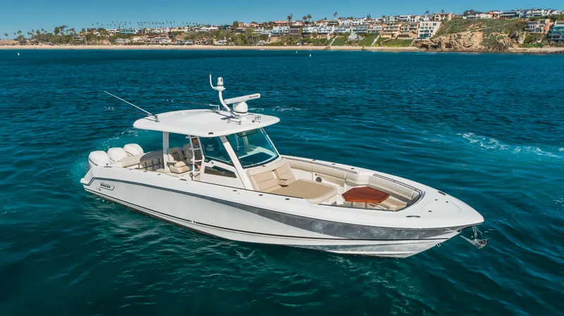 Robin Ann Yacht Photos Pics 2018 Boston Whaler 380 Outrage boat on clear blue water near coastal homes.