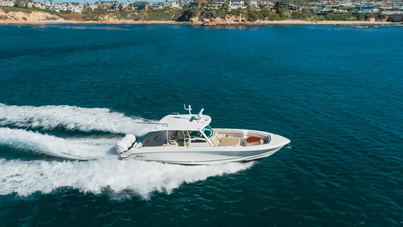 Robin Ann Yacht Photos Pics 2018 Boston Whaler 380 Outrage cruising on open water near coastline.