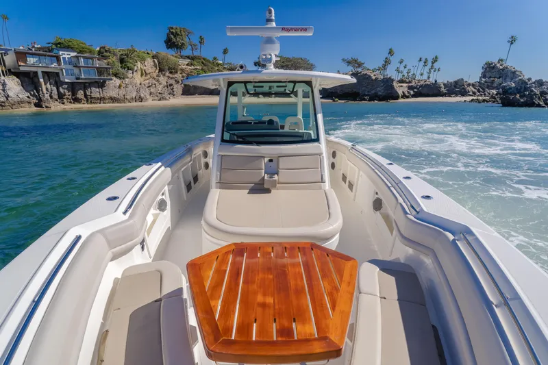 Robin Ann Yacht Photos Pics 2018 Boston Whaler 380 Outrage boat cruising near rocky coastline.