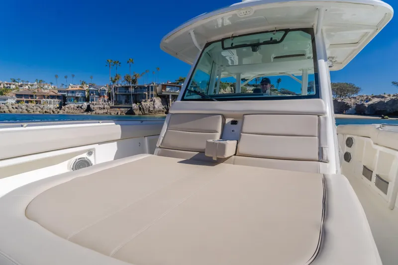 Robin Ann Yacht Photos Pics 2018 Boston Whaler 380 Outrage boat with spacious seating, docked near waterfront homes.