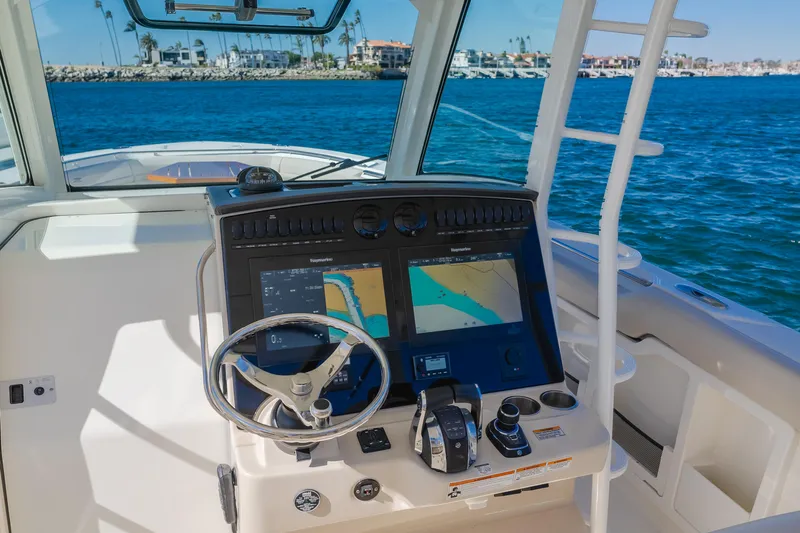 Robin Ann Yacht Photos Pics Boston Whaler 380 Outrage 2018 helm with navigation screens, steering wheel, and ocean view.