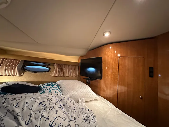  Yacht Photos Pics Cozy cabin interior of 2004 Regal Commodore 3860 with bed, TV, and porthole window.