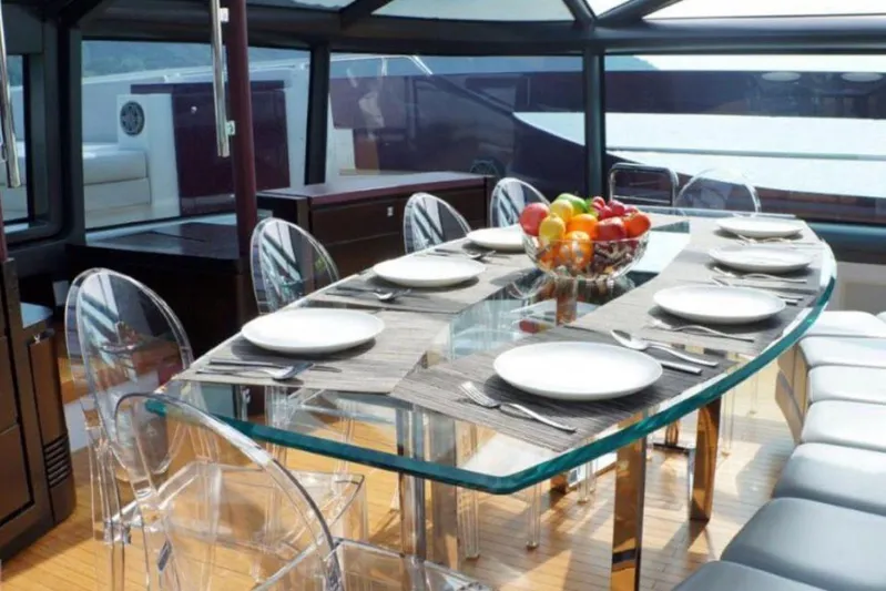 Argonaut Yacht Photos Pics Luxurious dining area on 2011 Baia ONE HUNDRED yacht with glass table and fruit centerpiece.