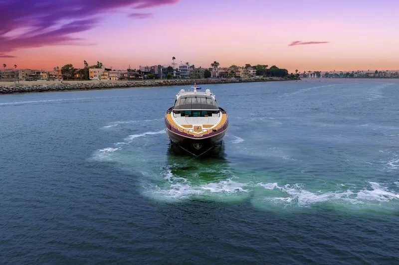 Argonaut Yacht Photos Pics Luxurious 2011 Baia yacht cruising at sunset near coastal cityscape.