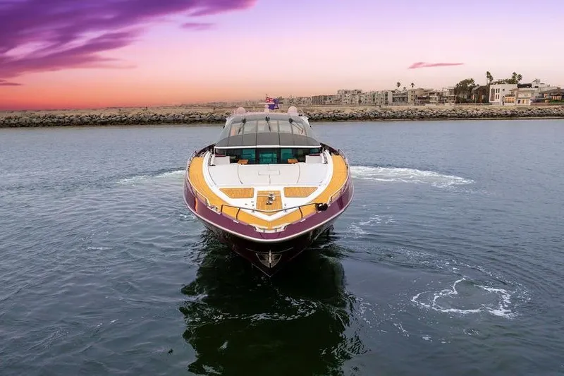 Argonaut Yacht Photos Pics Luxurious 2011 Baia yacht cruising at sunset near coastal cityscape.