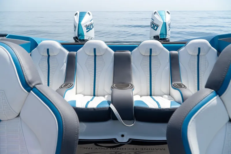  Yacht Photos Pics 2024 MTI 440X boat interior with stylish white and blue seating, ocean backdrop.