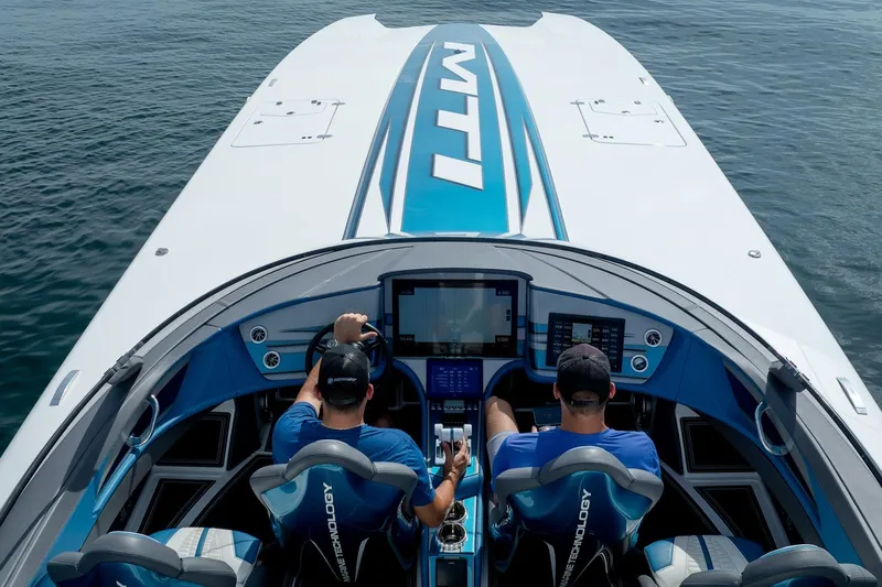  Yacht Photos Pics 2024 MTI 440X boat with two people navigating, featuring advanced dashboard technology.