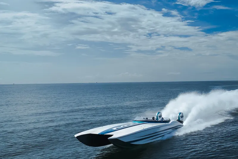  Yacht Photos Pics 2024 MTI 440X speedboat cruising on open water under a partly cloudy sky.