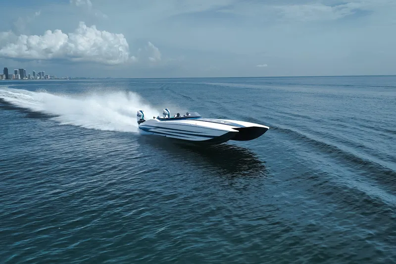  Yacht Photos Pics 2024 MTI 440X speedboat cruising on open water near city skyline.