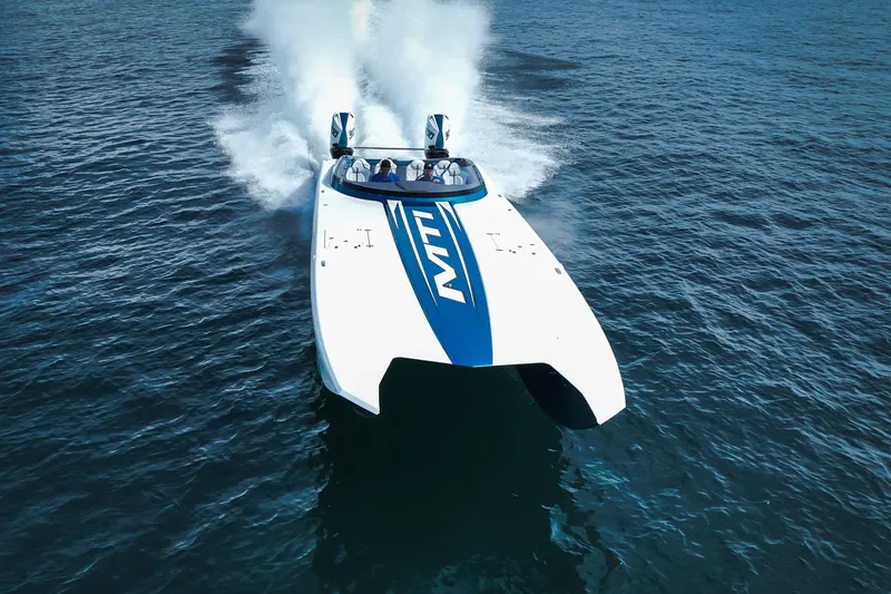  Yacht Photos Pics 2024 MTI 440X powerboat speeding on open water, showcasing sleek design and performance.