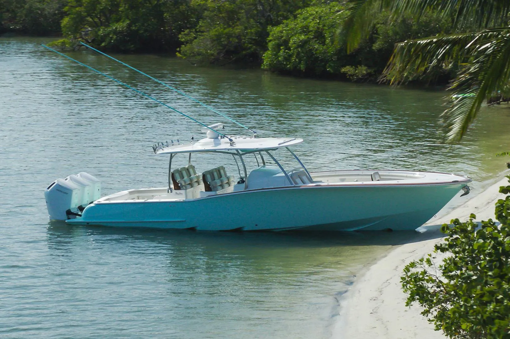 Manufacturer Provided Image: 2025 Mag Bay 43 CC boat docked on a sandy shore with lush greenery.