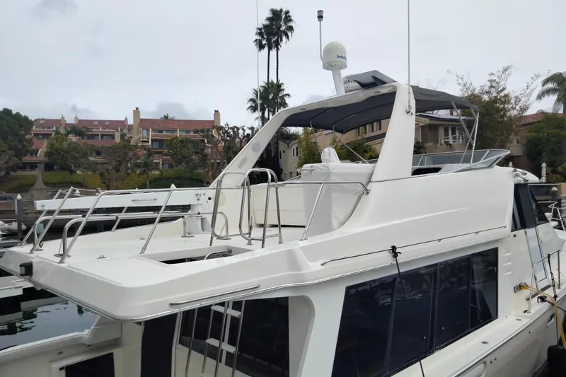 Coffey To Cocktails II Yacht Photos Pics 1998 Bayliner 4788 Pilot House Motoryacht docked near residential area.