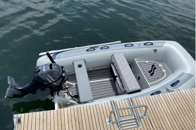 Yacht Photos Pics Inflatable boat with Yamaha motor docked beside wooden pier.